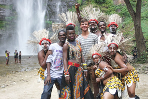 Junior music performance major Jeremy Feight poses with a group of Ghanaian musicians and dancers during the filming of a television commercial in Ghana. 