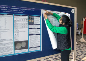 Photo By Claire Murray | Photo Editor. Senior biochemistry major Avani Dalal hangs a poster in preparation for Thursday’s Research and Scholarship Symposium.