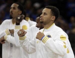 Golden State Warriors' Stephen Curry, right, wears his championship ring during an awards ceremony prior to the NBA basketball game against the New Orleans Pelicans Tuesday, Oct. 27, 2015, in Oakland, Calif. (AP Photo/Ben Margot)