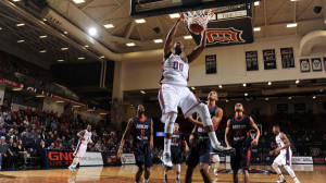 Photo from GoDuquesne. Junior Center Darius Lewis slams down a two-handed dunk in Saturday's win over Robert Morris. 