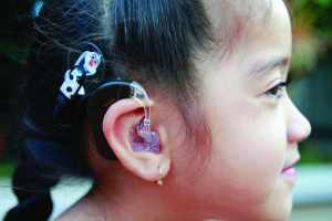 Cochlear implants, show above on kindergartner Taysia-Lee Alexander, have sparked a controversy in the United States among the deaf community. The Western Pennsylvania School for the Deaf is at the heart of the issue. 