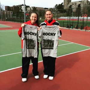 Courtesy of the Duquesne Duke  - Julianne Herman (right) and teammate Kylie Isaacs (left) hold up t-shirts depicting a famous scene from the movie “Rocky,” of which they are big fans. Herman is a four-time A-10 Rookie of the Week.