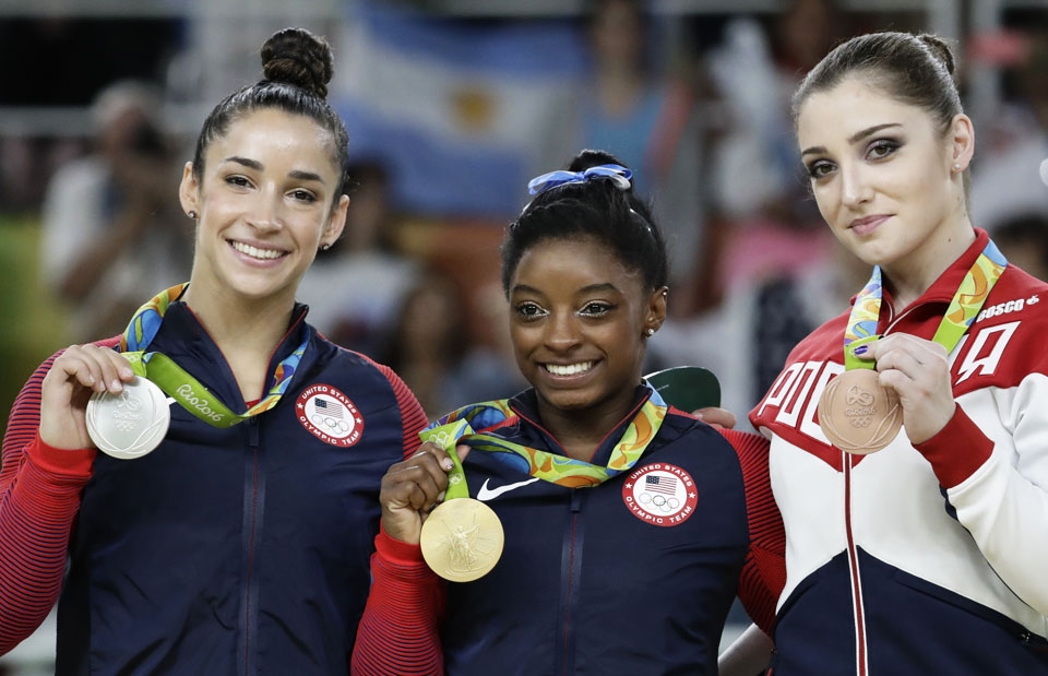 Bronze medallist Russia's Aliya Mustafina, right, gold medallist United States' Simone Biles, center, and silver medallist United States' Aly Raisman display their medals for the artistic gymnastics women's individual all-around final at the 2016 Summer Olympics in Rio de Janeiro, Brazil, Thursday, Aug. 11, 2016. (AP Photo/Dmitri Lovetsky)