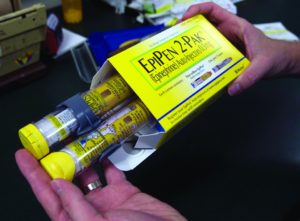 A pharmacist holds a package of EpiPens. The life-saving drug was victim to a massive price increase that made it difficult for many who needed it to actually attain.