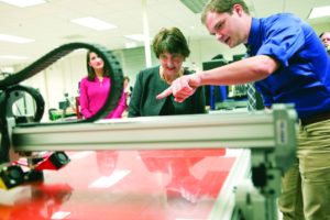 Anne Holton, wife of Democratic vice presidential candidate, Sen. Tim Kaine, D-Va., is shown a 3D printer by Virginia Western student and lab technician London Reinhard on Friday, Sept. 2, 2016 in Webber Hall in Roanoke, Va. Holton toured the community college while campaigning for Hillary Clinton and Tim Kaine, talking about the costs of community college and making it affordable for all Americans. (Heather Rousseau/The Roanoke Times via AP)