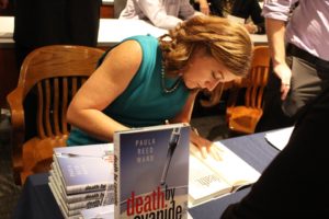 Kailey Love | Photo Editor  Paula Reed Ward signs a book at an event in the law school on Oct. 4. Ward has taught investigative reporting classes at Pittsburgh universities including Duquesne.